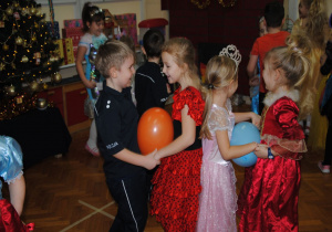 dzieci tańczą w parach z balonem trzymając się za ręce